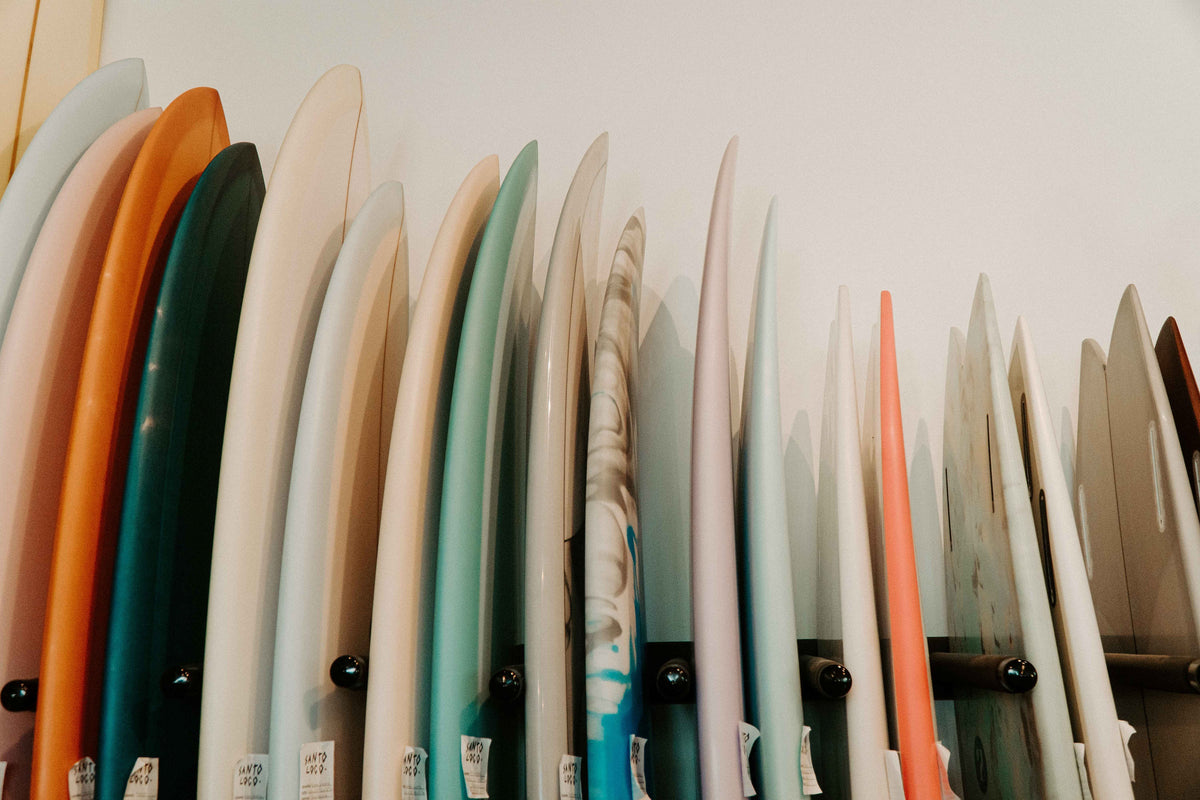 A row of surfboards on a rack