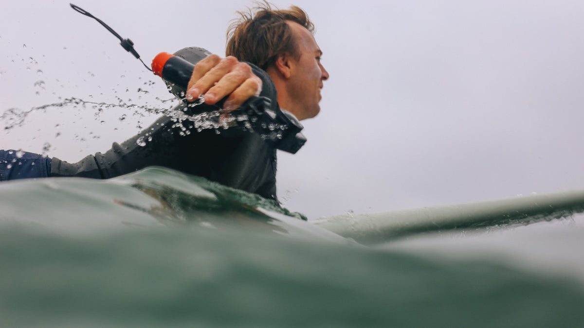 Surfer paddling with GoPro The Handler
