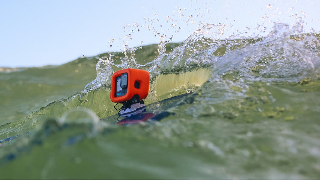 Wave crashing over GoPro mounted on surfboard